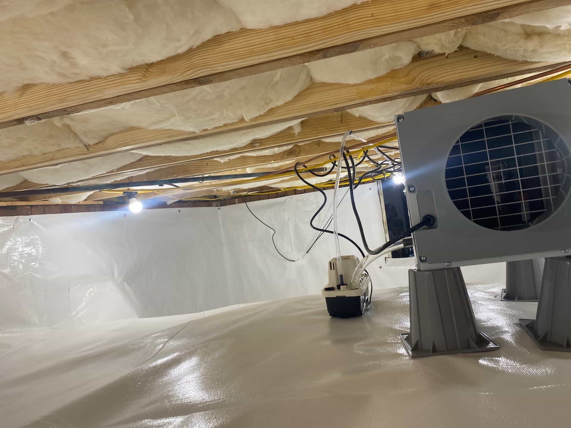 HydroHelp911 Crawl Space & Foundation Repair installing a vapor barrier, dehumidifier, and insulation in a crawl space.