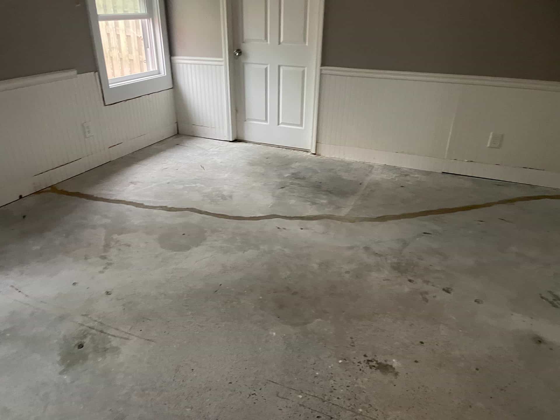 HydroHelp911 Crawl Space & Foundation Repair crew sealing a concrete floor crack with polyurethane crack sealer.