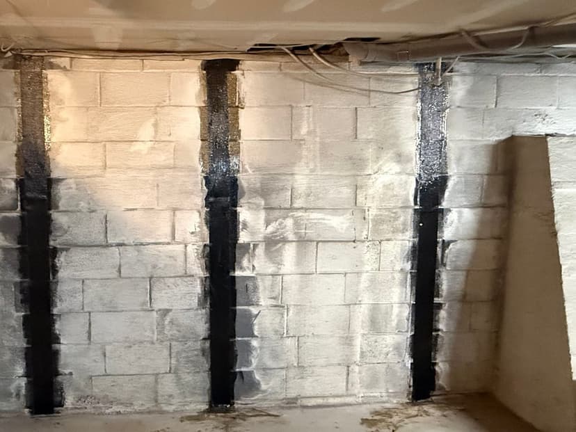 Carbon fiber straps bonded upright to a painted block basement wall