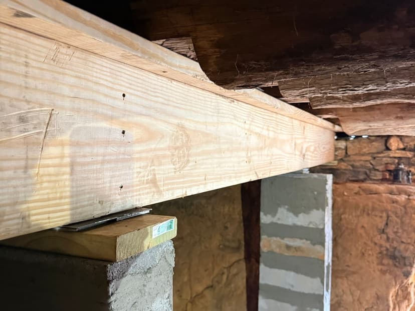 A new wood beam set on concrete block piers under the floor framing