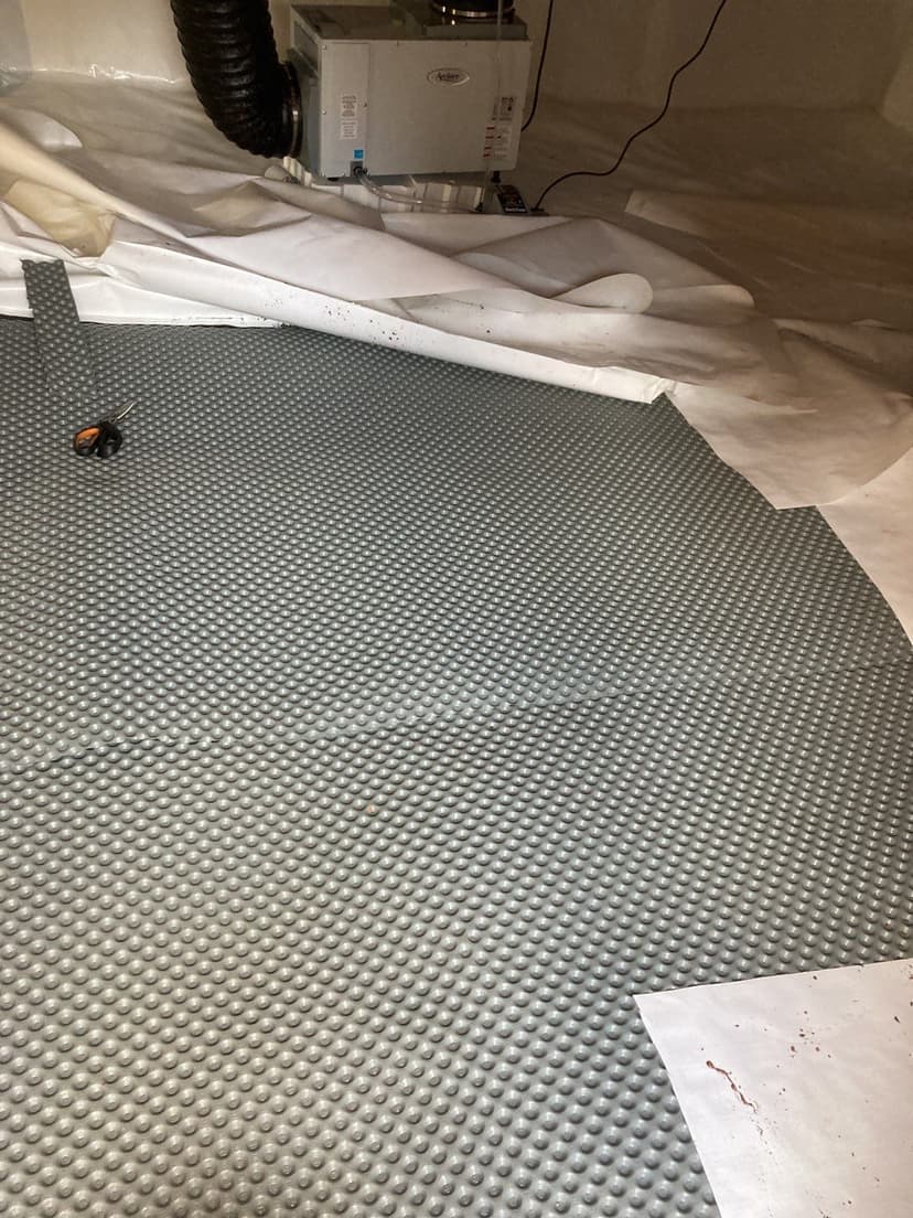 HydroHelp911 Crawl Space & Foundation Repair installing drainage matting for crawl space encapsulation with a dehumidifier.