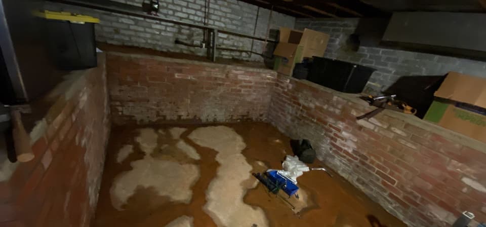 HydroHelp911 Crawl Space & Foundation Repair inspecting basement flooding with wet walls and efflorescence.