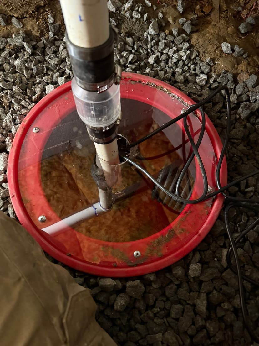 HydroHelp911 Crawl Space & Foundation Repair installing a sump pump with a discharge pipe, check valve