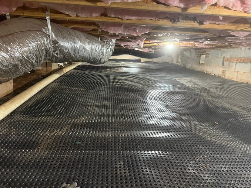 HydroHelp911 Crawl Space & Foundation Repair installing drainage matting in a crawl space with insulation overhead.