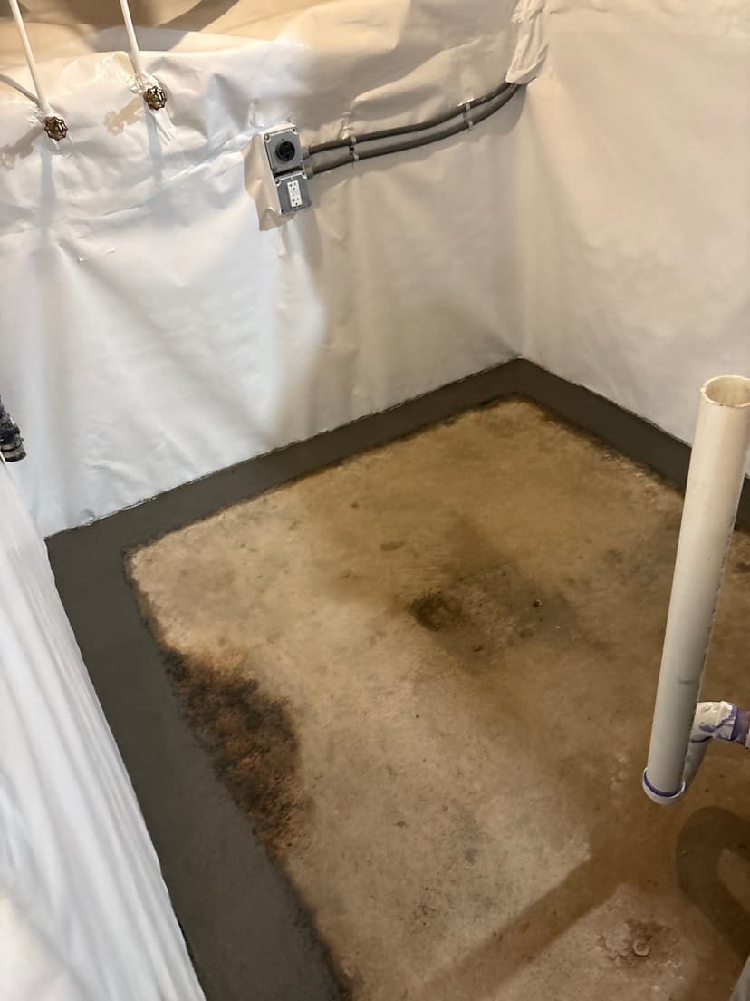 HydroHelp911 Crawl Space & Foundation Repair installing a vapor barrier and interior drainage system in a basement.