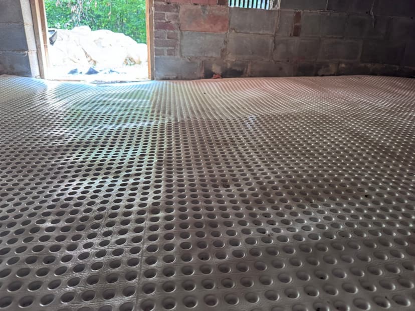 HydroHelp911 Crawl Space & Foundation Repair installing drainage matting as part of a crawl space drainage system.