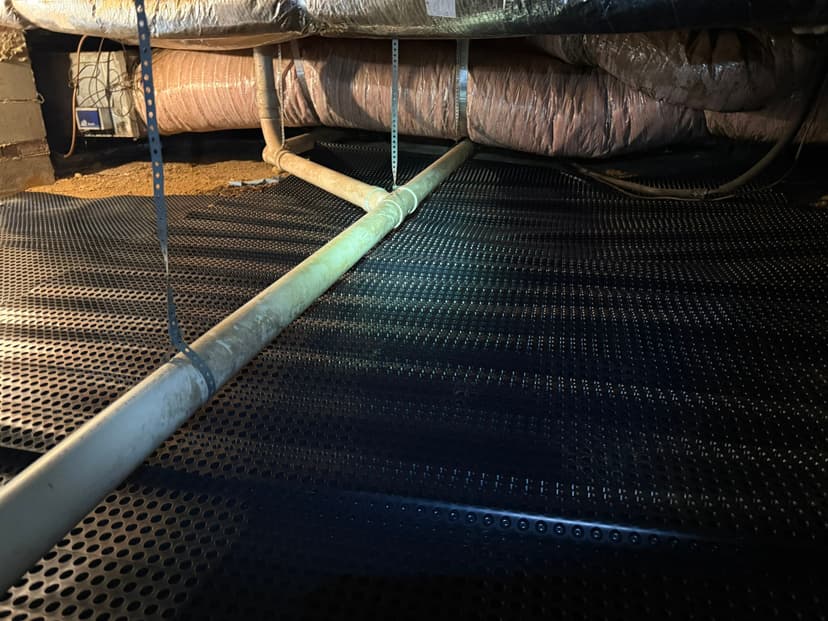 HydroHelp911 Crawl Space & Foundation Repair installing drainage matting beneath HVAC ducts in a crawl space.