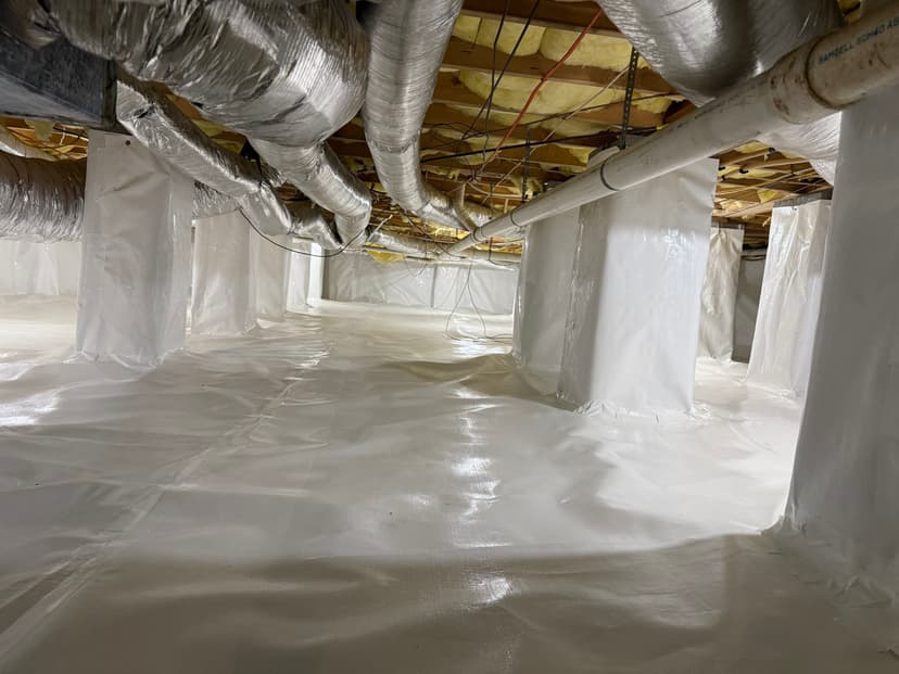 HydroHelp911 Crawl Space & Foundation Repair completed crawl space encapsulation with a white vapor barrier and insulation.