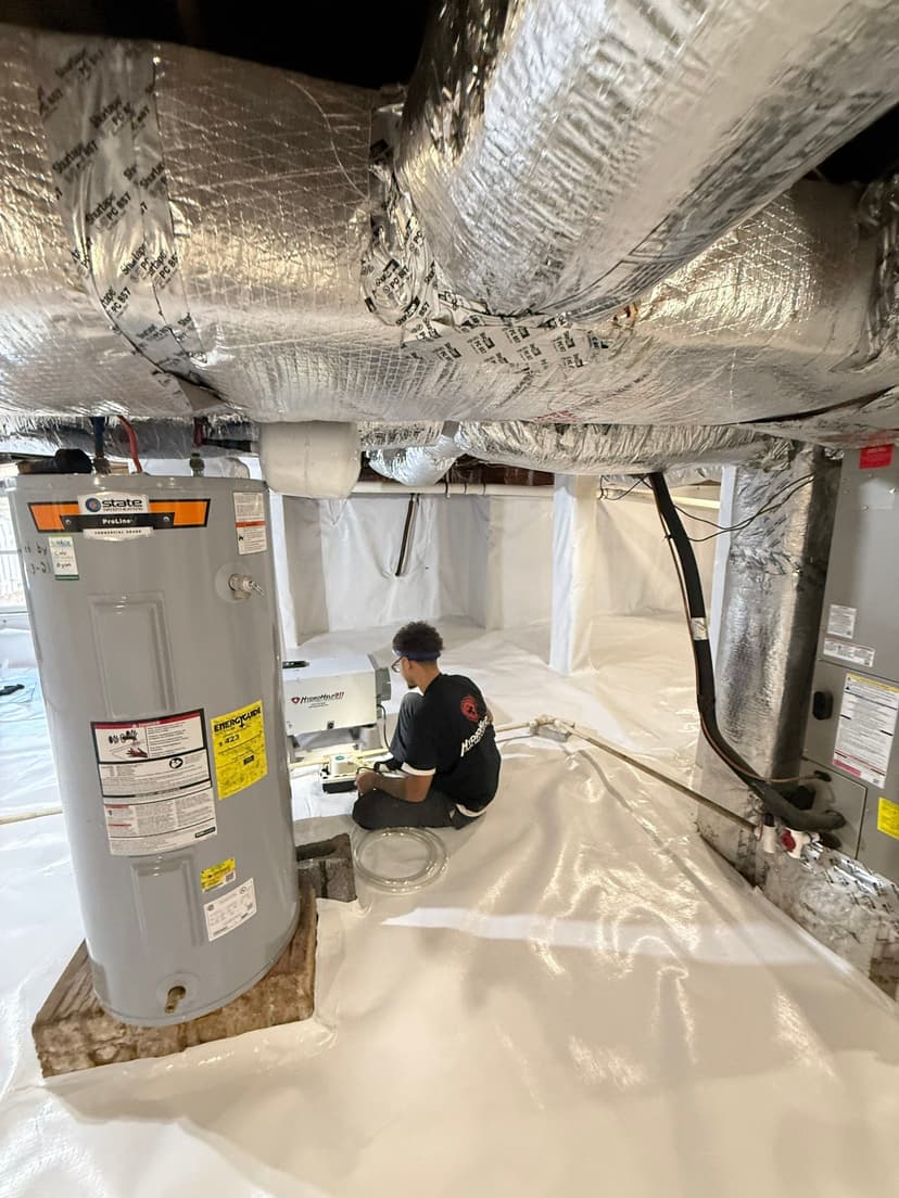 HydroHelp911 Crawl Space & Foundation Repair technician installing a crawl space dehumidifier within a vapor barrier system.