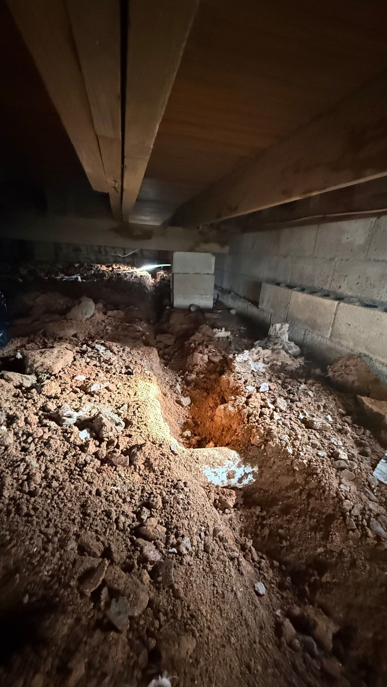 HydroHelp911 Crawl Space & Foundation Repair installing a drainage system in a damp crawl space.