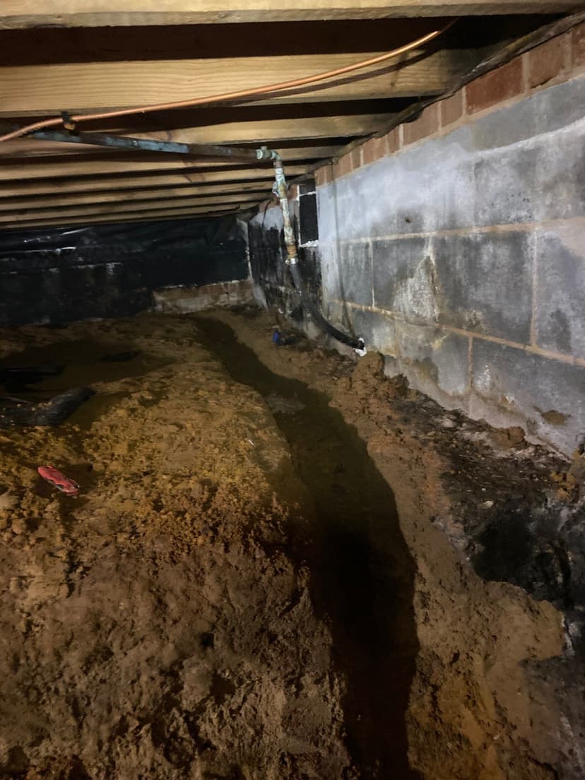 HydroHelp911 Crawl Space & Foundation Repair installing a drainage trench in a crawl space.