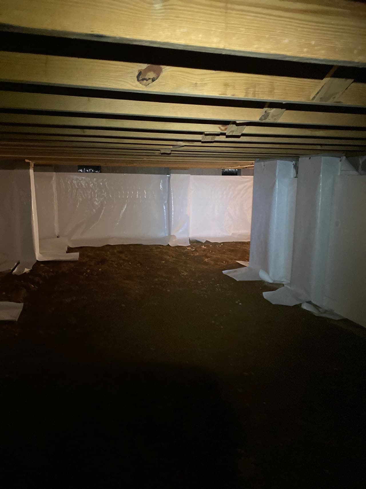 HydroHelp911 Crawl Space & Foundation Repair installing a white vapor barrier for crawl space encapsulation