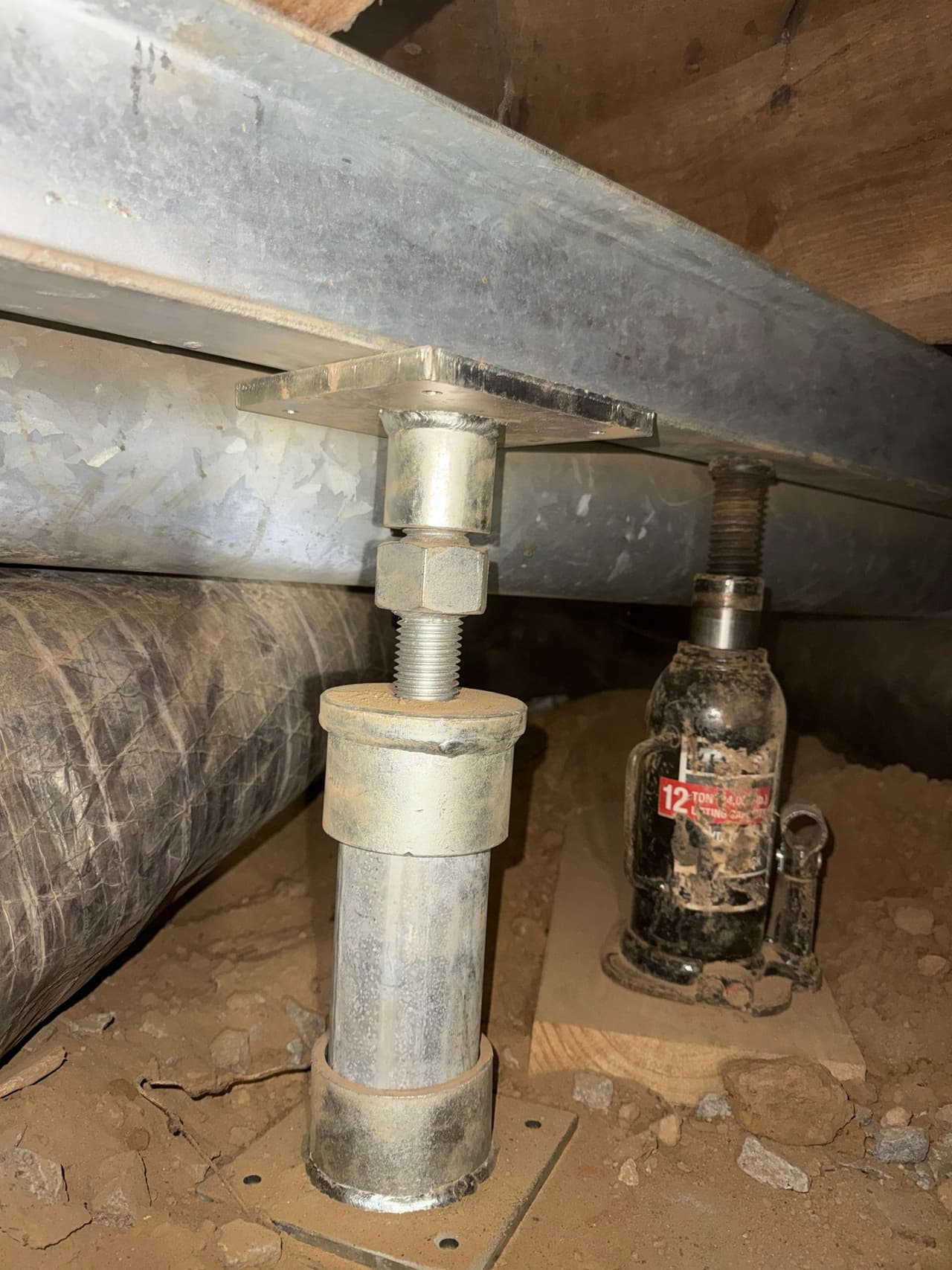 HydroHelp911 Crawl Space & Foundation Repair installing adjustable crawl space jacks to support a steel beam.