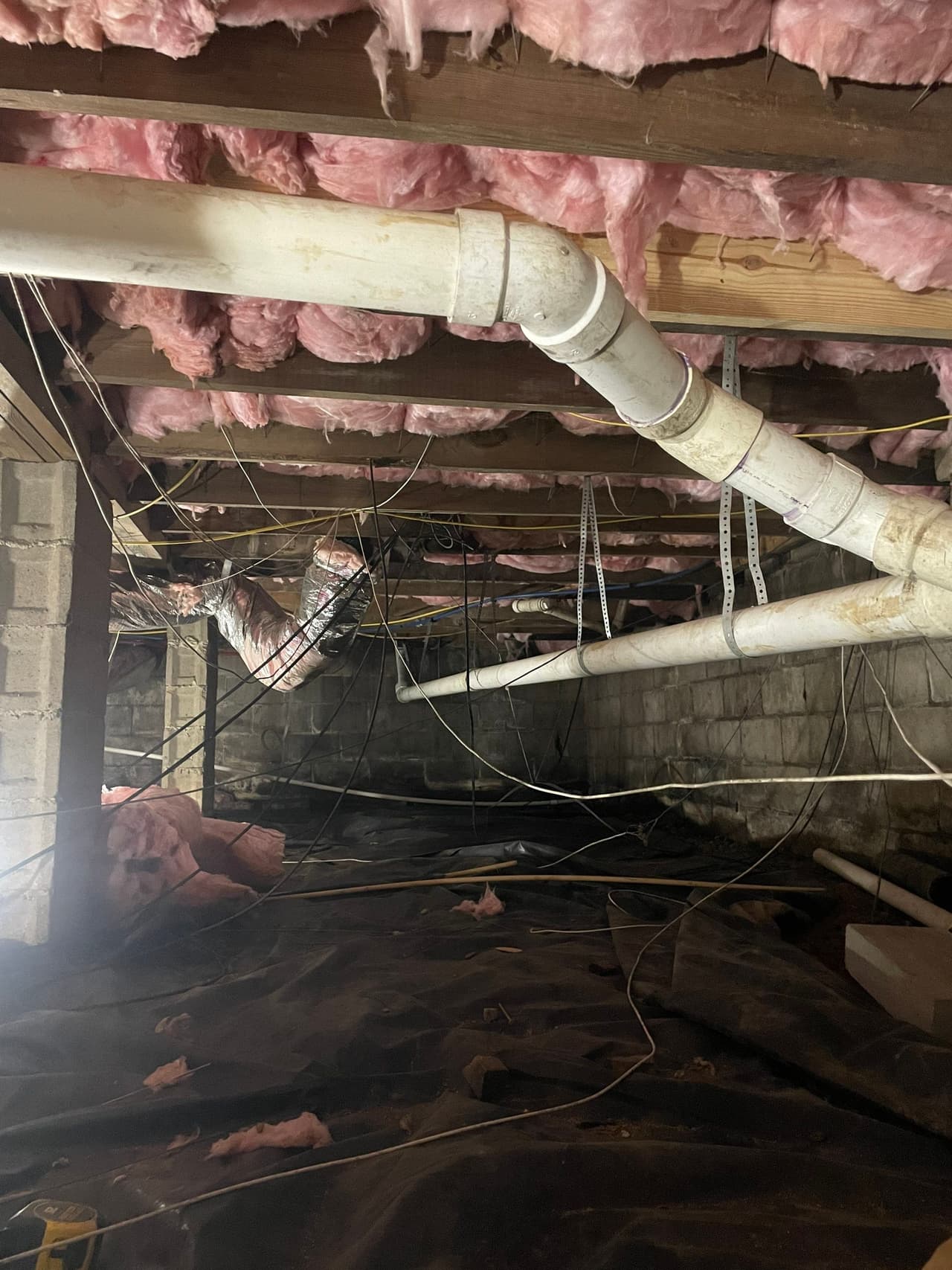 HydroHelp911 Crawl Space & Foundation Repair inspecting a damp crawl space with deteriorating insulation.