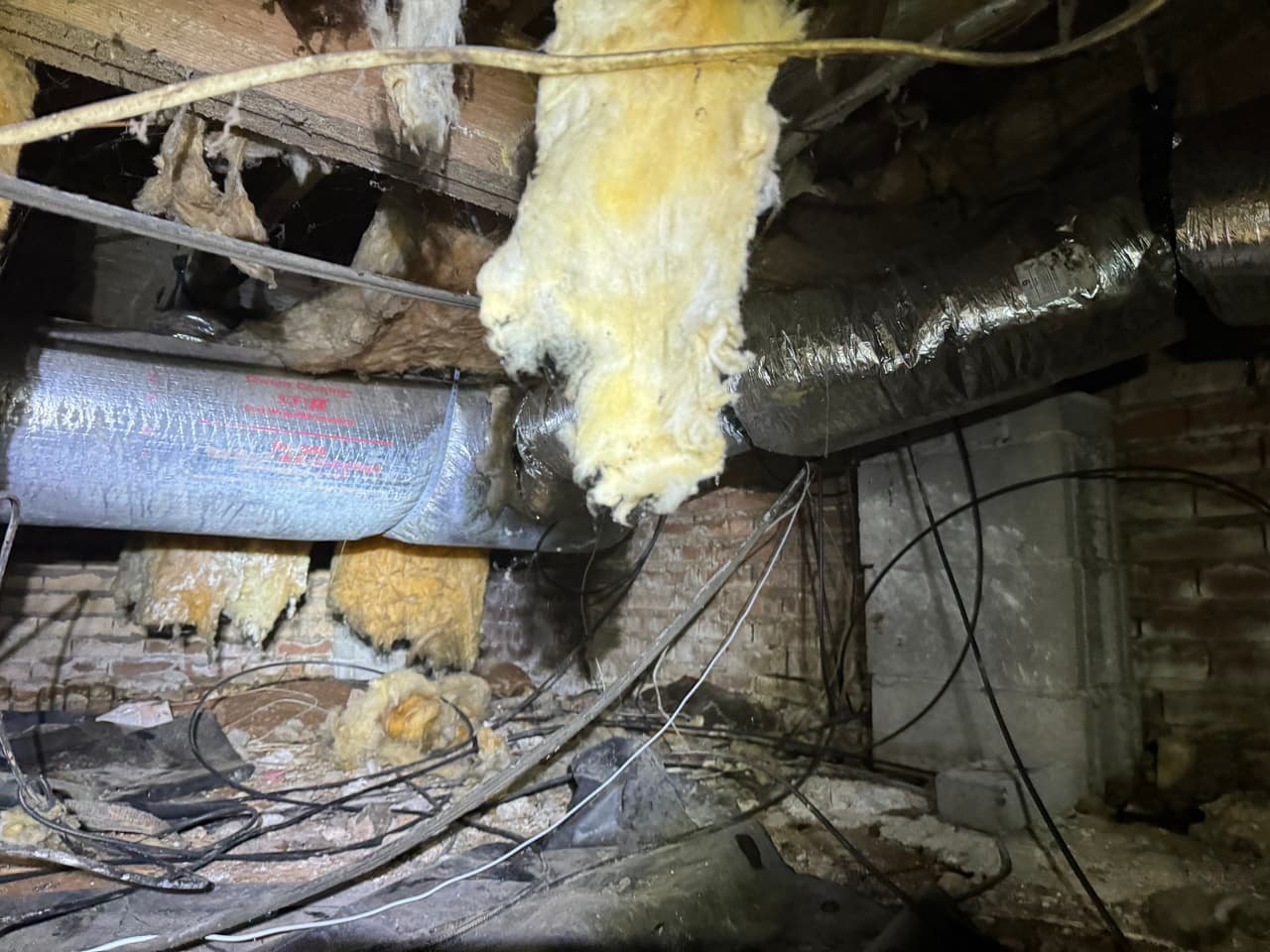 HydroHelp911 Crawl Space & Foundation Repair inspecting deteriorating insulation and moisture in a crawl space.