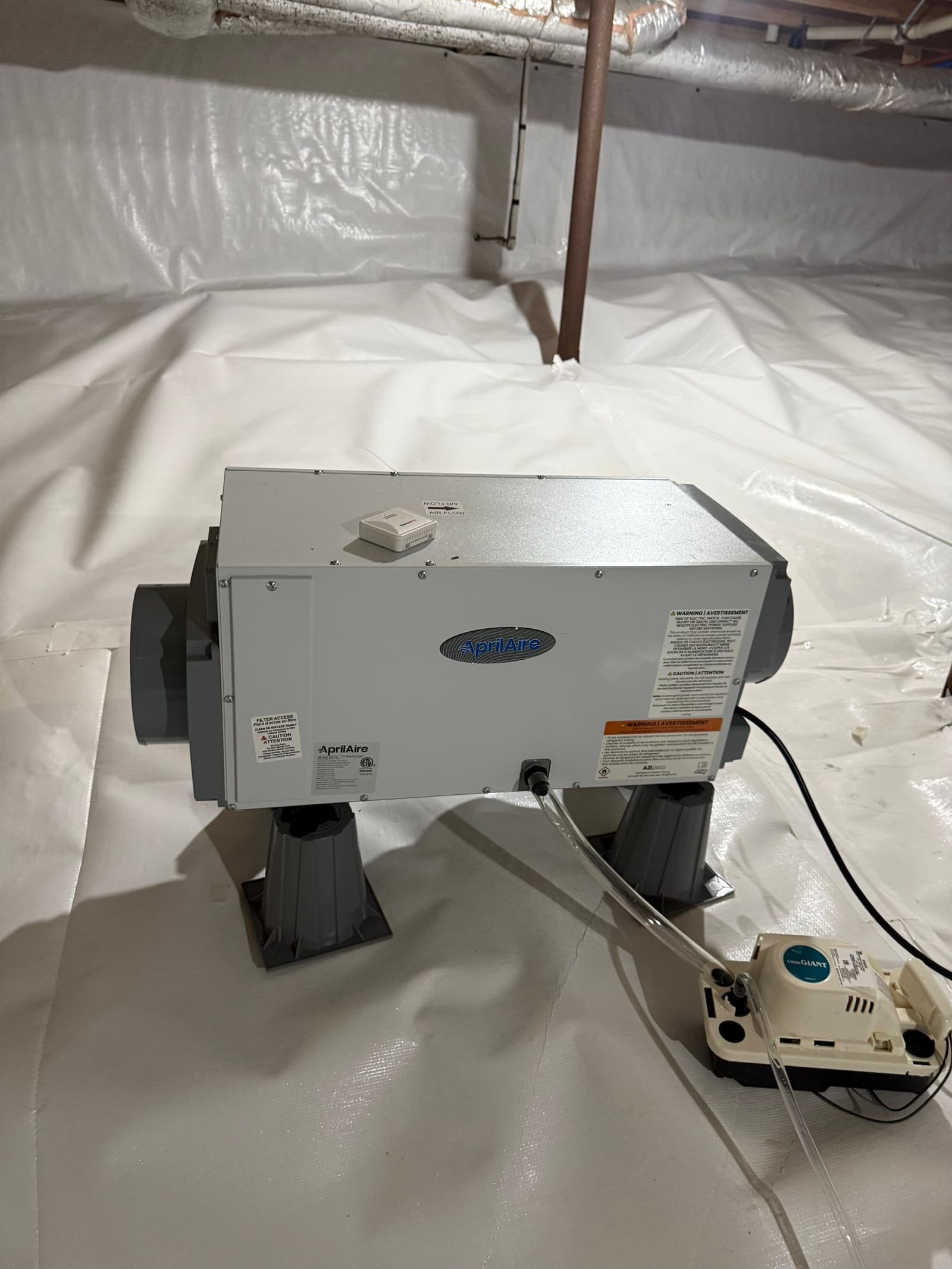 HydroHelp911 Crawl Space & Foundation Repair installing a crawl space dehumidifier on a white vapor barrier.
