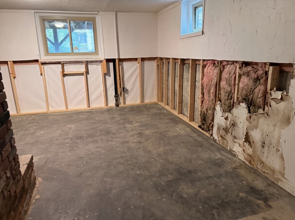 HydroHelp911 Crawl Space & Foundation Repair inspecting severely water damaged basement drywall and insulation.