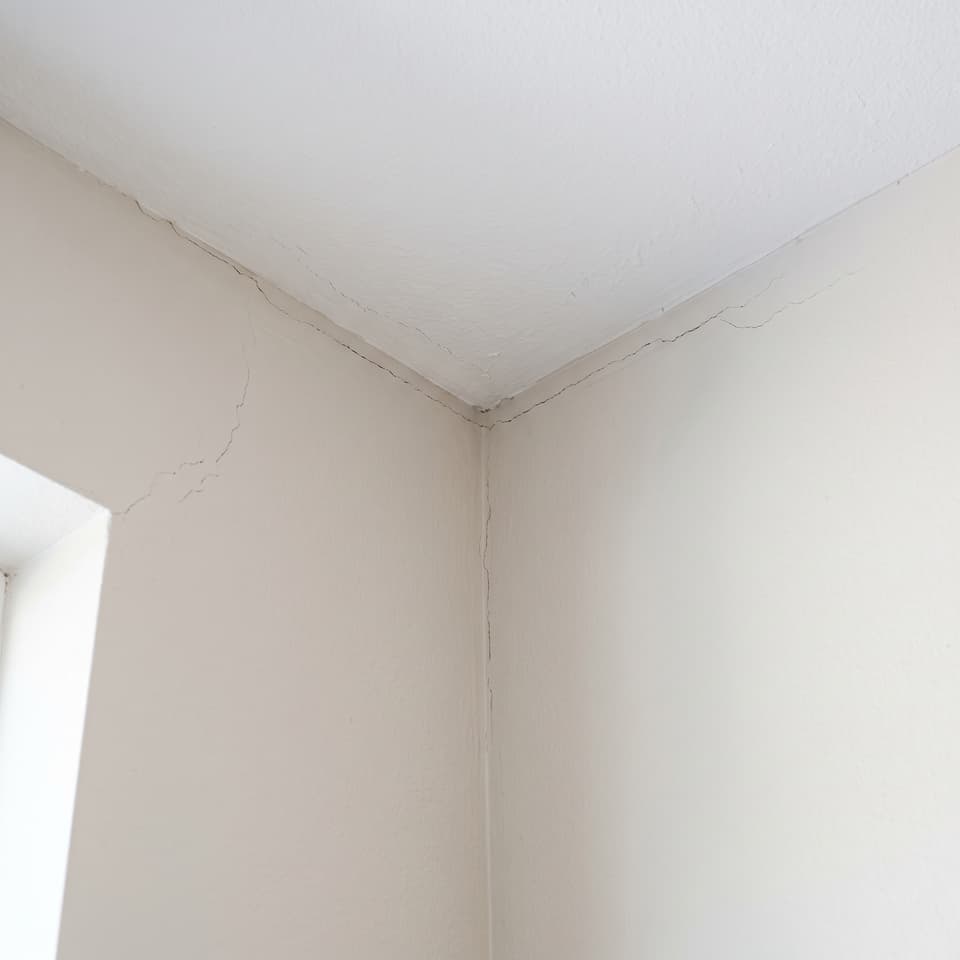 HydroHelp911 Crawl Space & Foundation Repair inspecting diagonal cracks in drywall, ceiling, and door frame.