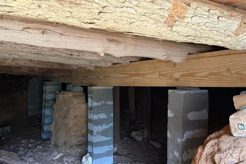 Concrete block piers supporting a timber beam in a crawl space