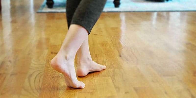 Person walking barefoot on a hardwood floor