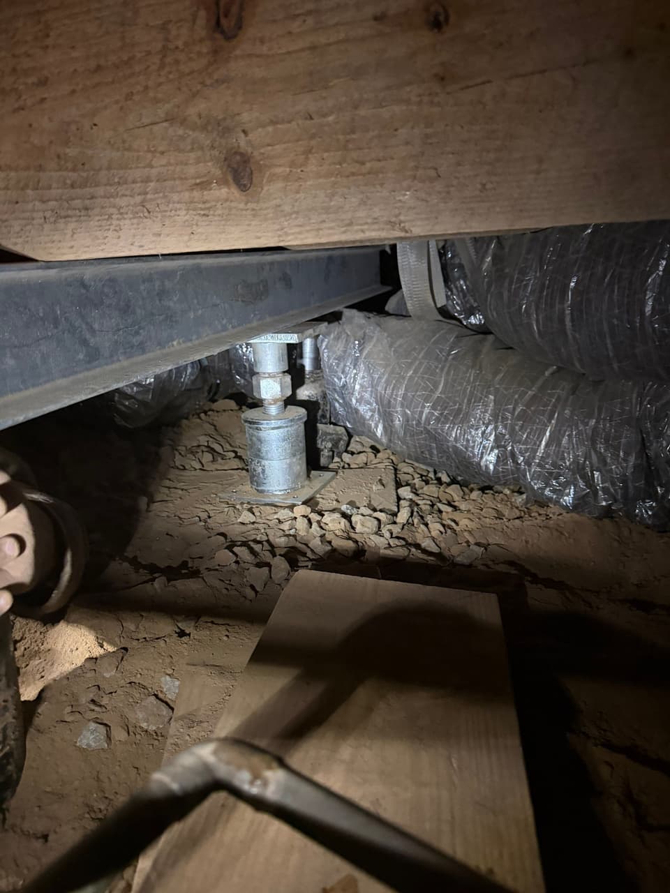 HydroHelp911 Crawl Space & Foundation Repair installing adjustable steel jacks to support a steel beam and floor joists.